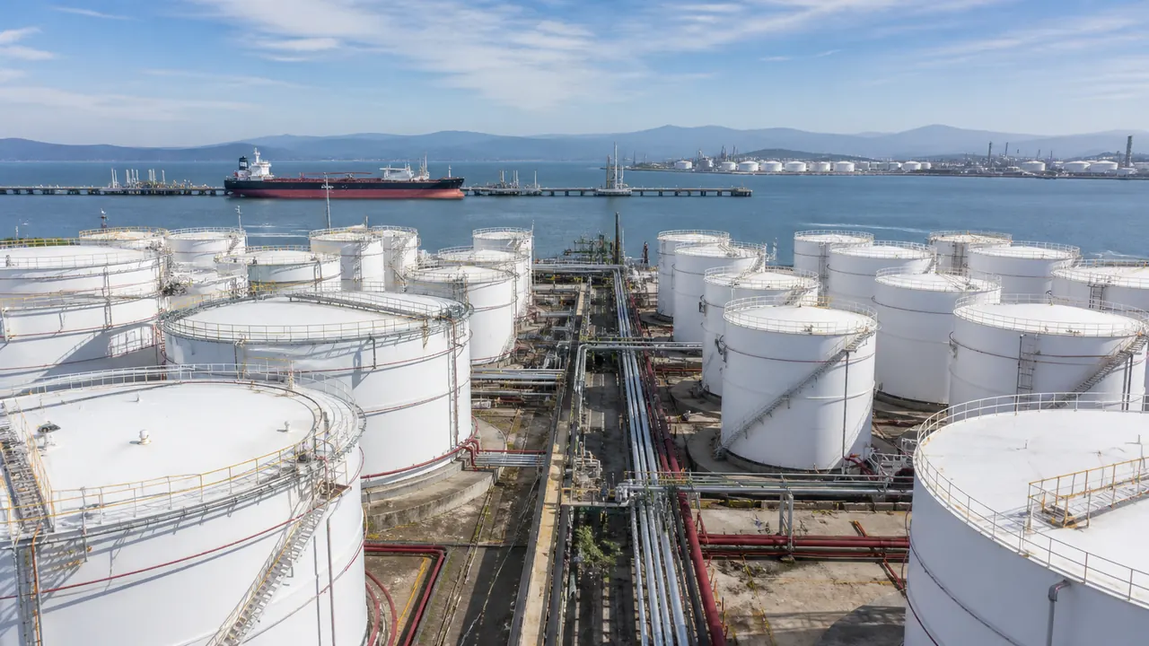 Illustration of an oil storage terminal beside a harbour and tanker.